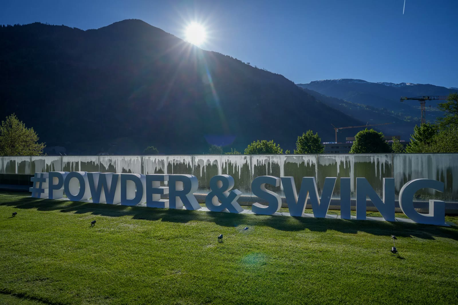 Powder & Swing Schriftzug vor Alpenkulisse